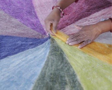 Bunte Filzplatte in Regenbogenfarben entsteht unter geschickten Händen